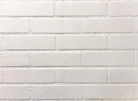 Texture straight flat brick wall. Background painted white. Stock Photos