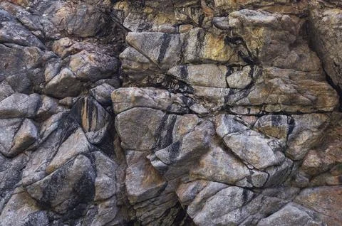 Texture of surface of gray rocky mountain with cracks close-up Stock Photos