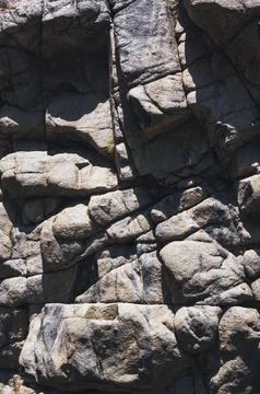 Texture of surface of gray rocky mountain with cracks close-up Stock Photos