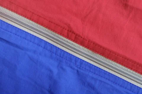 Texture of the surface of two colored fabric with a zippered diagonal lock Stock Photos