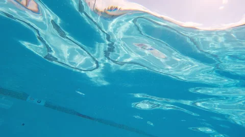 Texture of surface of water in swimming pool with depth marker, sunny afternoon Stockbeeldmateriaal 248081074