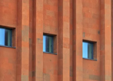 Texture of terracotta brick wall with parallel pattern and windows Stock Photos