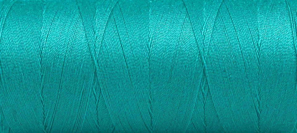 Texture of threads in a spool of green color on a white background Stock Photos
