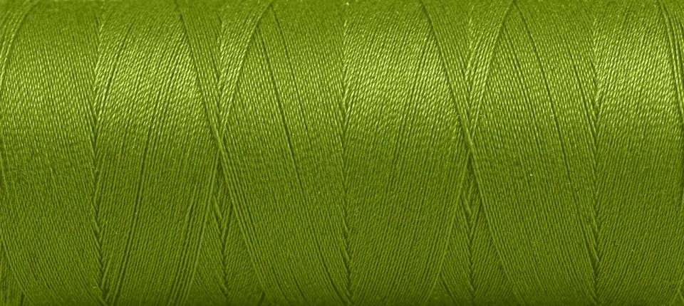 Texture of threads in a spool of green color on a white background Stock Photos