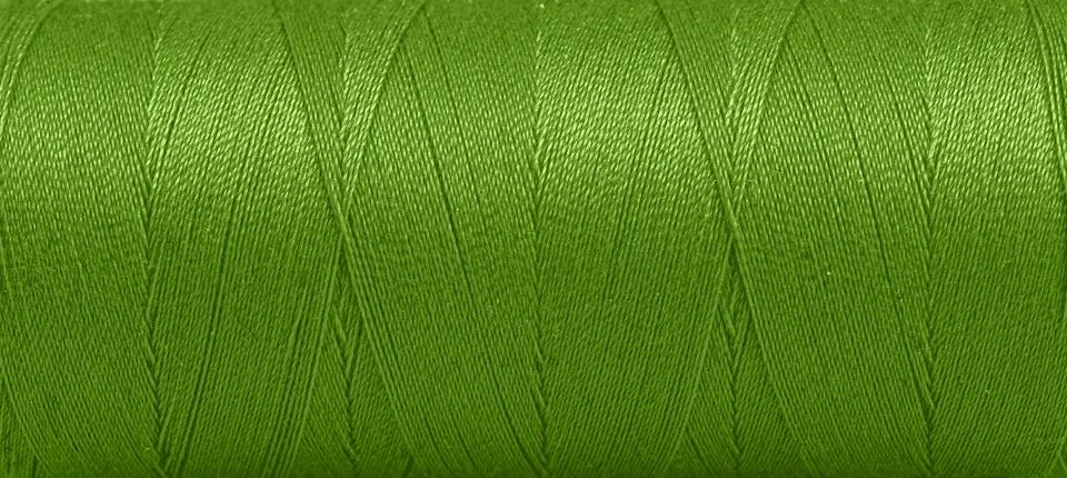 Texture of threads in a spool of green color on a white background Stock Photos