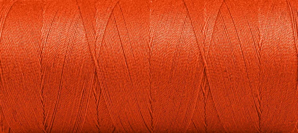 Texture of threads in a spool of Orange color on a white background Stock Photos