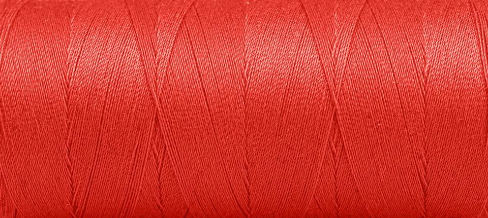Texture of threads in a spool of red color on a white background Stock Photos