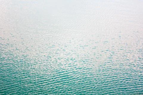 Texture of transparent clear surface of turquoise azure water with small ripp Stock Photos