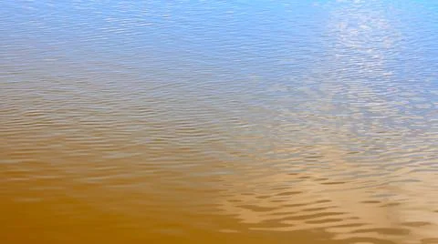 Texture of transparent clear surface of turquoise azure brown amber water with Stock Photos