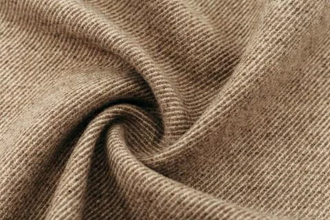 Texture of twisted dense material of brown color. Piece of fabric with waves Stock Photos