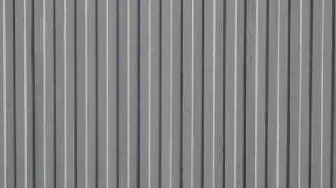Texture of a vertical fence made of gray profiled metal sheeting. Stock Photos