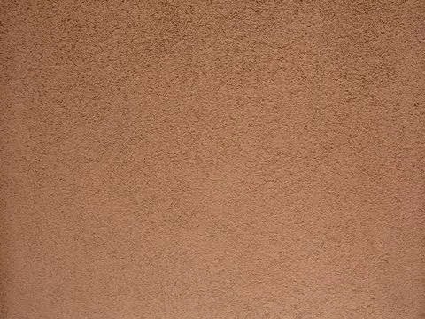 Texture. The wall is covered with light brown concrete plaster. Background. Stock-Fotos