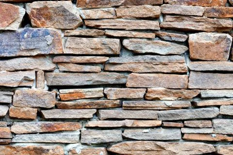 The texture of the wall lined with sandstone stone. Stock Photos