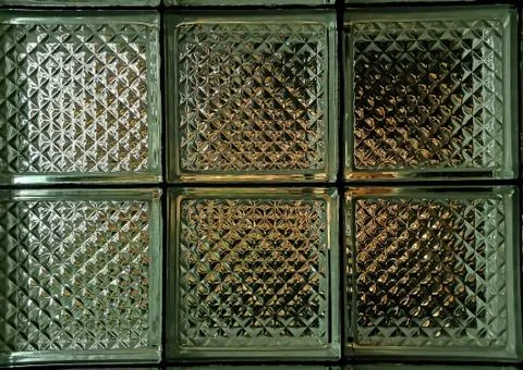 Texture of a wall made of transparent ribbed glass tiles. Stock Photos