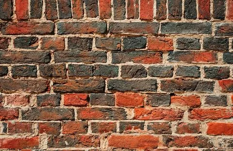 The texture of the wall of red and black burnt bricks in high resolution. C.. Stock Photos