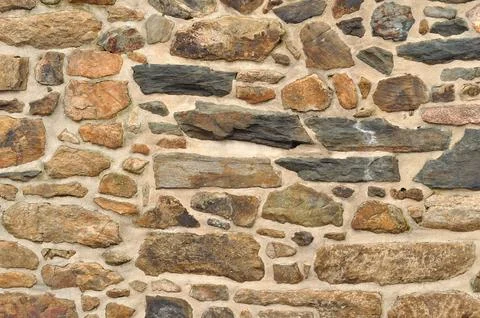 Texture of a wall surface builted with irregular stones Stock Photos