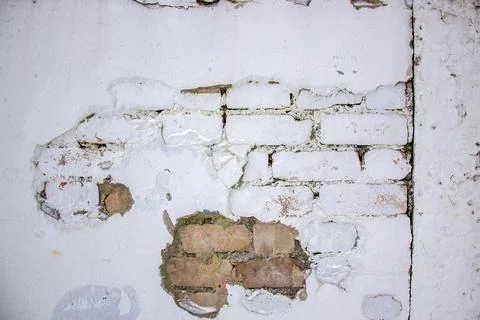 Texture wall with white paint shows patches where bricks exposed and wear Stock Photos
