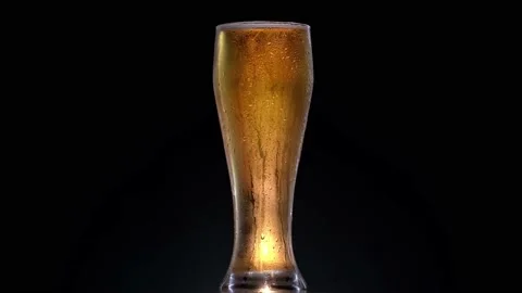 Texture of water drops on the bottle of beer. Rotation glass with beer in 4k Stock Footage 155924964