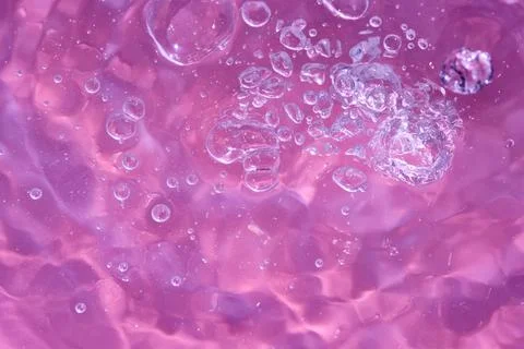 Texture of waves of bubbling water on a pink background Stock Photos