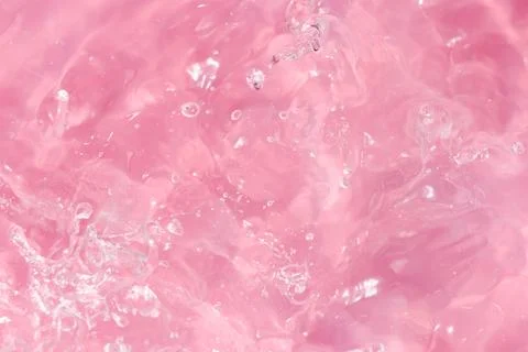 Texture of waves of bubbling water on a pink background Stock Photos