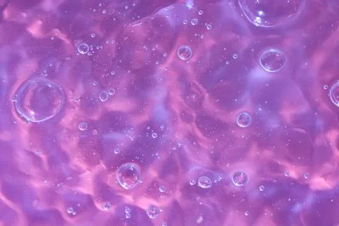 Texture of waves of bubbling water on a pink background Stock Photos