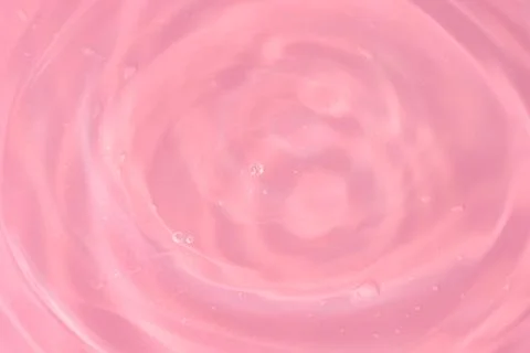 Texture of waves of bubbling water on a pink background Stock Photos