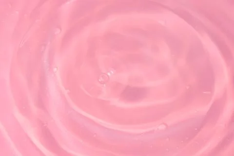Texture of waves of bubbling water on a pink background Stock Photos