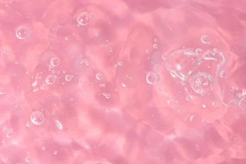 Texture of waves of bubbling water on a pink background Stock Photos