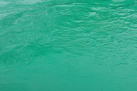 The texture of the waves of turquoise color of fast-flowing water in the rive Stock Photos
