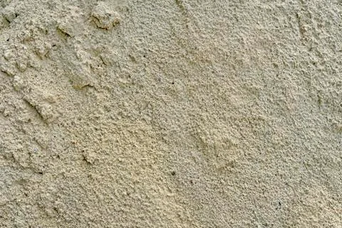 Texture of wet sand. Brown wet sand. Background of fine and wet sand. Stock Photos