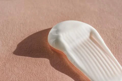 The texture of the white cream on a pink background. Stock Photos