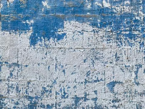 Texture of a white dirty wall with peeling blue paint. Stock Photos