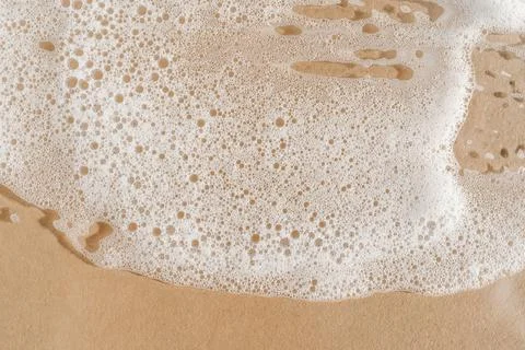 Texture of white foam on a beige background. Stock Photos