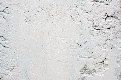 Texture of a white painted wall with cracks and bumps. Light gray stone textu Stock Photos