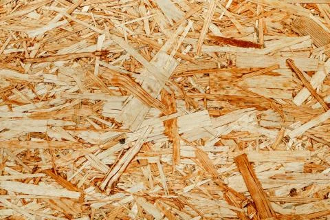 The texture of the wooden surface of pressed chips and sawdust closeup. Stock Photos
