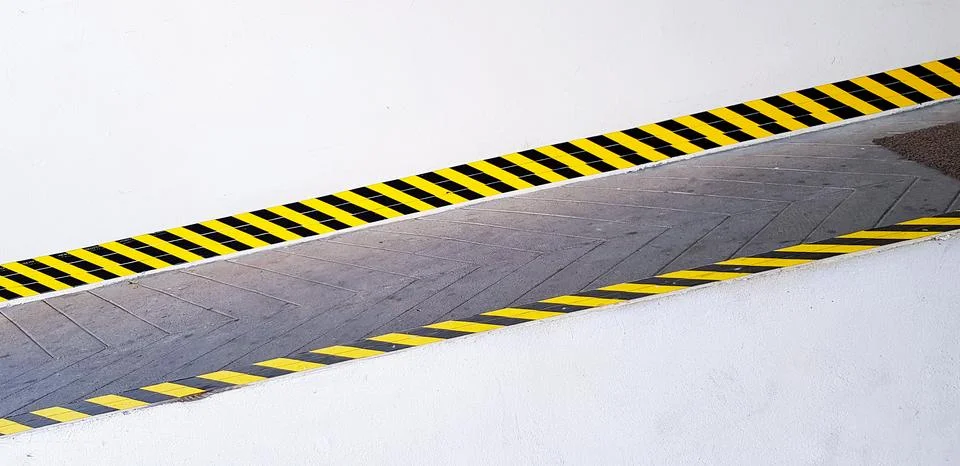 Texture of yellow and black pattern line on slope pathway for sign warning Stock Photos
