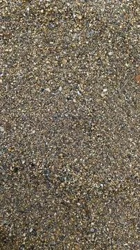Texture of yellow sand with small pebbles. Sand pattern Stock Photos