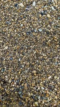 Texture of yellow sand with small pebbles. Sand pattern Stock Photos