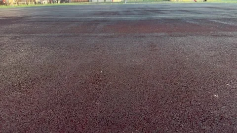 Textured asphalt pavement with reddish-brown surface and painted lines  Stock Footage 340261373