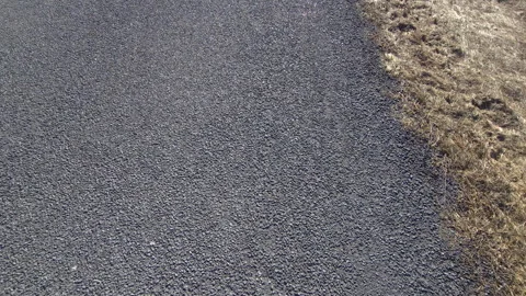 Textured asphalt roadside with grass edge Stock Footage 269975811