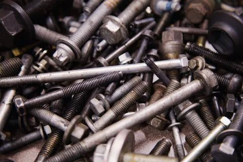 A textured backdrop of assorted bolts and screws in varied sizes, scattered.. Stock Photos