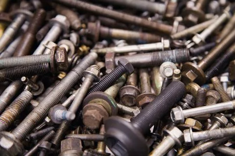 A textured backdrop of assorted bolts and screws in varied sizes, scattered.. Stock Photos