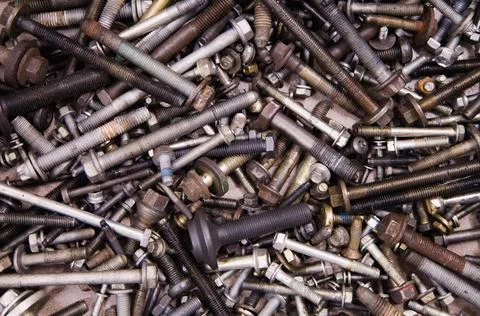 A textured backdrop of assorted bolts and screws in varied sizes Stock Photos