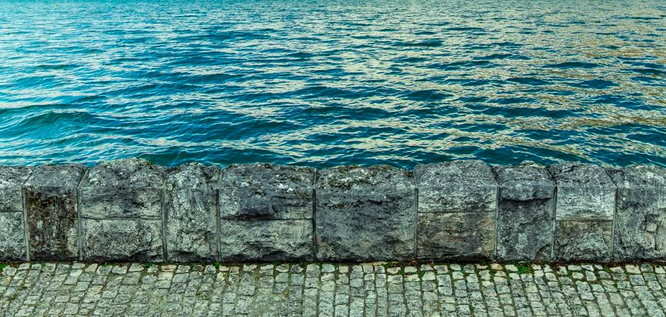 Textured backdrop pattern of stone waved waterfront coast line with wavy rese Stock Photos