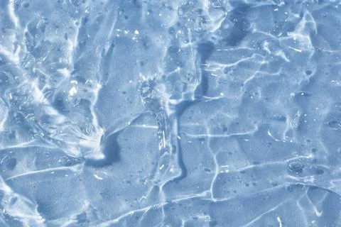 Textured backdrop of turquoise colored clear rippling water surface on beach Foto stock