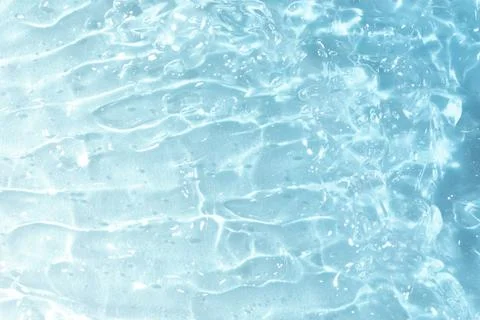 Textured backdrop of turquoise colored clear rippling water surface on beach Foto stock