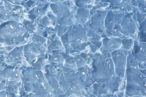 Textured backdrop of turquoise colored clear rippling water surface on beach Stock Photos