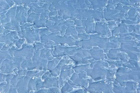 Textured backdrop of turquoise colored clear rippling water surface on beach Foto stock
