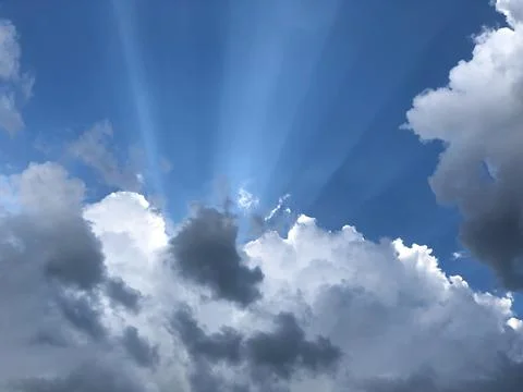 The textured background is a celestial landscape with thunderclouds, rays o.. Fotos de archivo