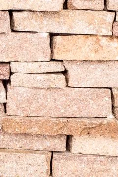 Textured background made of light red stones wall Stock Photos
